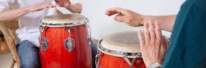 2 trommelnde Hände, die auf Kongas spielen.